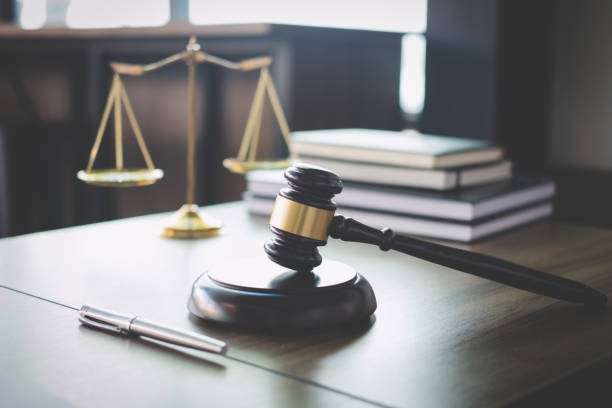 scales of justice on desk with notebooks and gavel.